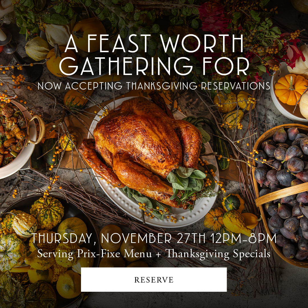 Top view of a roasted turkey surrounded by pumpkins, grapes, and autumn leaves. Text over image promotes Thanksgiving reservations for Thursday, November 27th, 12 PM-8 PM, featuring a prix-fixe menu and specials.